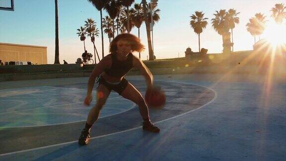 年轻女子在威尼斯海滩球场练习篮球