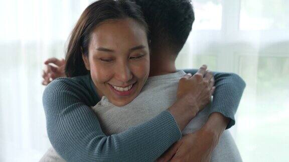 年轻的亚洲爱夫妻拥抱在家里有浪漫的一起关系