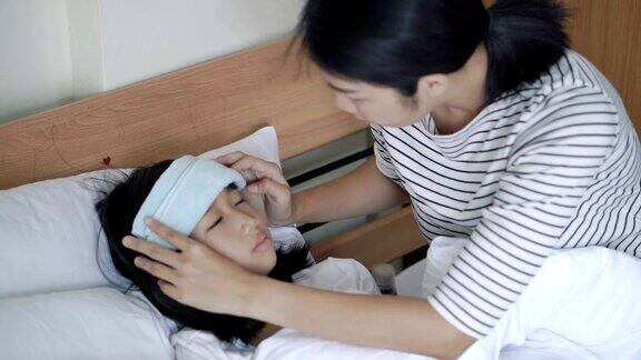 母亲抚摸女儿额头测量体温呵护健康