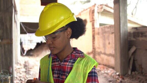 在工地戴着保护性耳塞的非洲女建筑工人