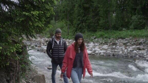 一对年轻夫妇一起在山里散步河在后台