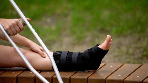 女性有拐杖坐凳腿上有踝关节支撑骨折拉伤