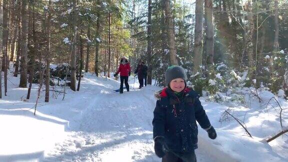 小男孩在冬天暴风雪后的森林里奔跑