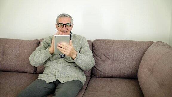 老人在家用数码平板电脑进行视频通话