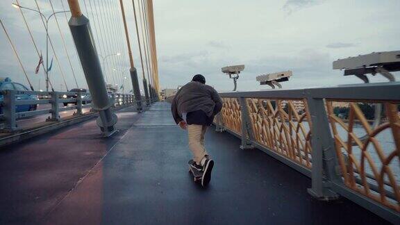 在长周末的桥上玩滑板的男性