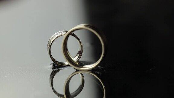 结婚戒指放在黑白相间的水面上新郎的戒指滚到新娘的戒指