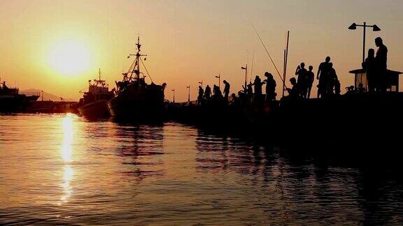 日落时分一个人在码头上钓鱼的剪影
