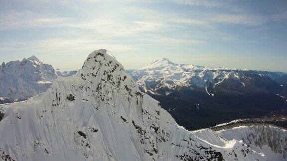 三角形的陡峭岩石的山峰空中飞行近距离看雪山的北方喀斯喀特山和贝克山自然冬季揭示背后的北方喀斯喀特山