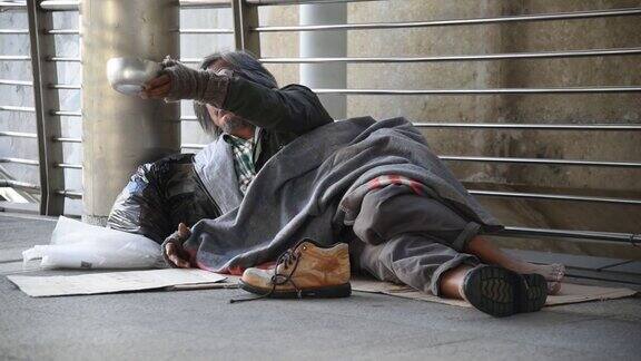 一个无家可归的人向人们乞讨
