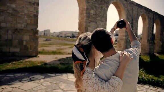 年轻的游客夫妇在暑假用相机自拍