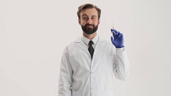 微笑的男人医生和蓝色的手套拿着注射器