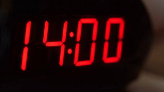 黑色数字时钟屏幕的特写显示14.00在黑色背景上闪烁着红色数字现代计时器系统及霓虹灯、电报警装置