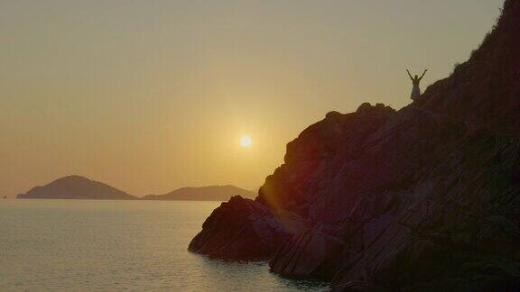 一个女人在日落时沿着海岸冥想厄尔巴岛