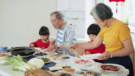 爷爷奶奶向孩子们展示如何在春节做火锅的手持镜头