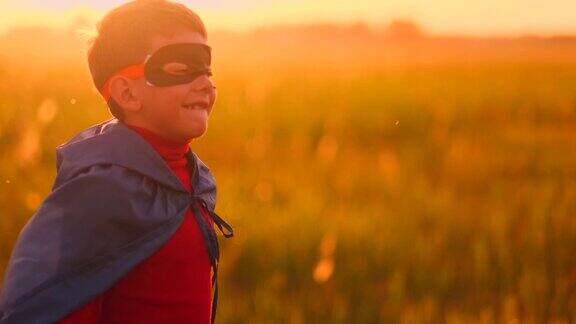 在日落时分的田野里戴着面具和斗篷的超级英雄男孩