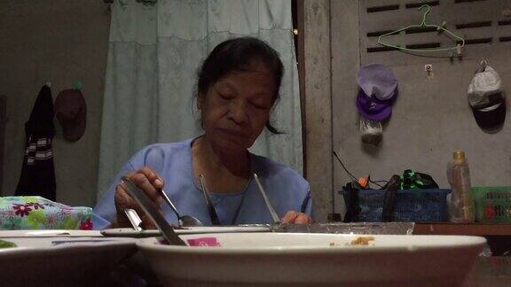 亚洲老妇人在吃米饭