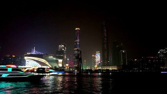 夜间照亮现代城市景观和河边的办公大楼时光流逝