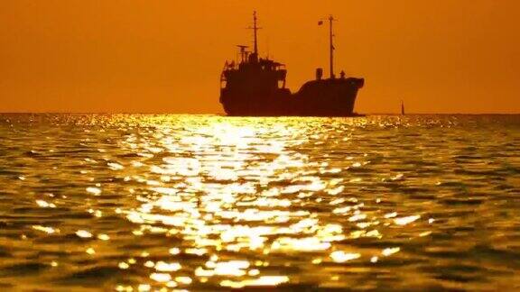日落时分海上一艘货船的剪影