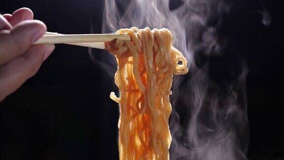 筷子美味的面条在黑暗的背景