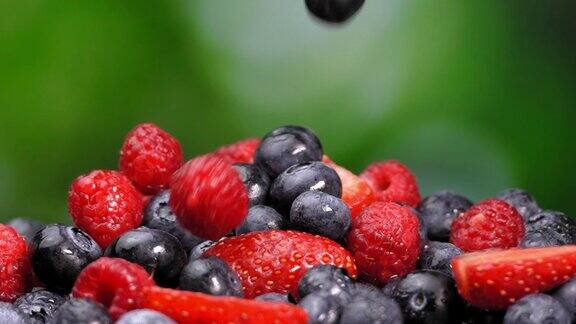 野生蓝莓、覆盆子和草莓片在盘子里旋转