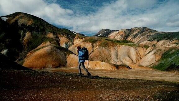 在冰岛的Landmannalaugar一名妇女在彩色山脉附近徒步旅行