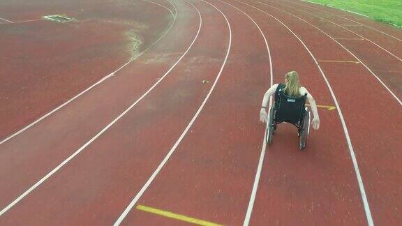 一名女性残疾人在田径场上坐着轮椅进行训练