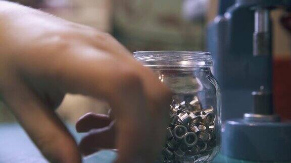 不同的银网眼零件在于透明的罐子特写