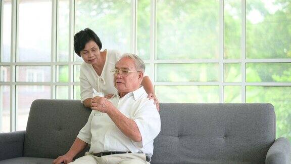 幸福的老夫妇喝牛奶和花时间一起在家里健康和退休