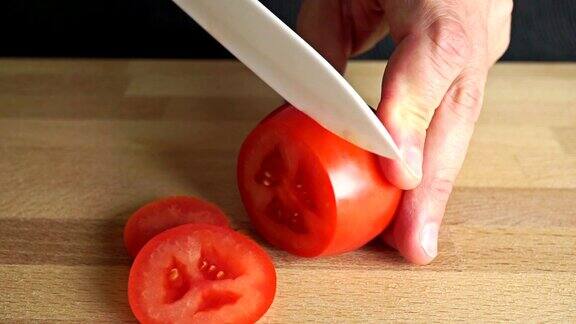 业余厨师用竹切板切红番茄