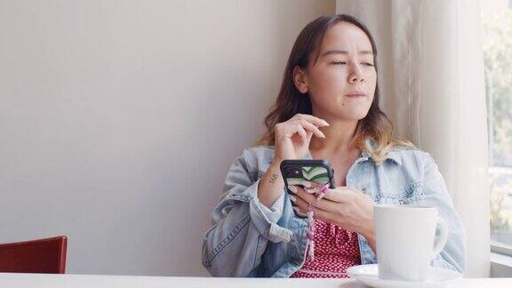 一个迷人的年轻女子坐在咖啡店里发短信的4k视频片段