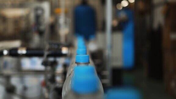 装有水的塑料瓶一个接一个地在传送带上排成一行