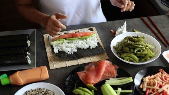 泰国女厨师用黄瓜鳄梨和烟熏鲑鱼制作寿司