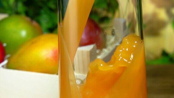 美味的芒果汁倒在一个罐子里旁边是装满芒果的木箱