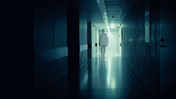 医院里的医生走出黑暗的走廊戏剧性地消失了悲伤、忧郁的生命丧失主题
