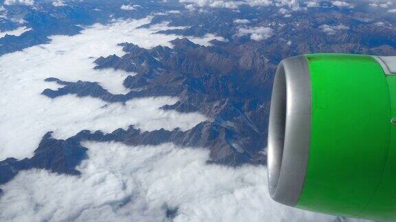 美丽的景色透过飞机的窗户飞机飞过云层和山脉