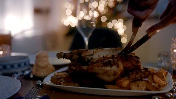 圣诞节期间在餐桌上切烤鸡的妇女