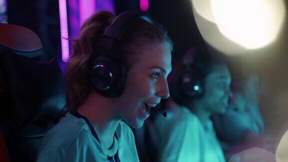 女性玩家戴着耳机玩电子游戏在游戏中玩网络竞技玩家之间交流比赛