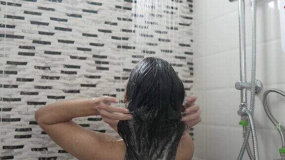 一个年轻的女人在浴室里洗澡洗头发