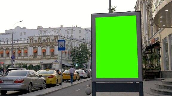 繁忙街道上的一个绿屏广告牌