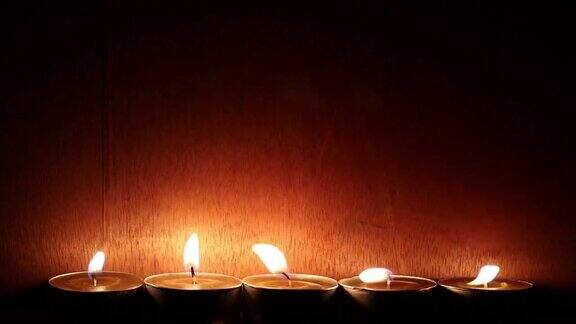 黑暗的房间里有一排木墙蜡烛