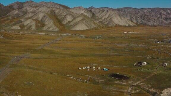 鸟瞰风景荒野蒙古包营地与高山和冰川河流的观点在吉尔吉斯斯坦