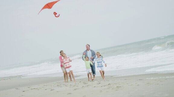 健康的白人家庭玩玩具风筝落海滩