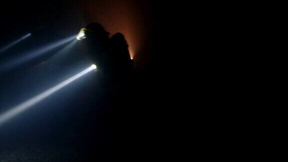 消防队员在一个充满浓烟的黑暗隧道中进行救援行动