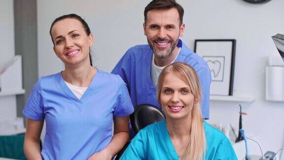 三个微笑牙医在牙医诊所的肖像
