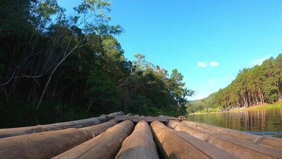 乘着竹船在大河中迎着天然的树木和森林航行