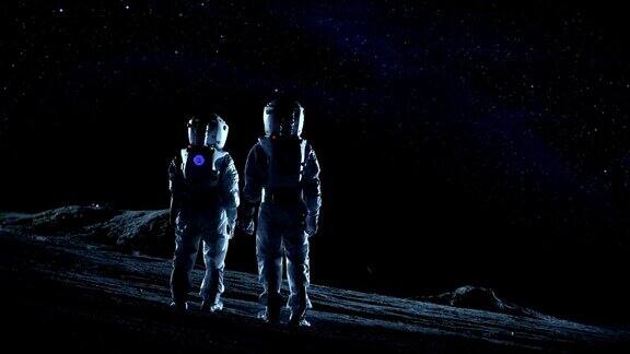 两名宇航员穿着太空服站在外星星球上看星星和星系太空旅行和地外殖民概念