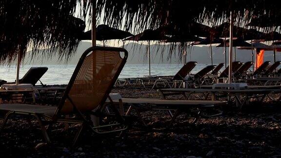 海岸边的茅草伞和躺椅的剪影