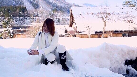 冬天年轻女子在白川乡玩雪这是日本旅游的最佳地点