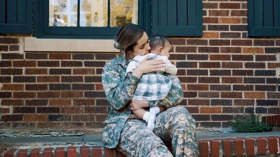 悲伤的女士兵害怕离开女婴去执行军事任务