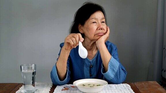 年老的亚洲妇女厌倦了食物